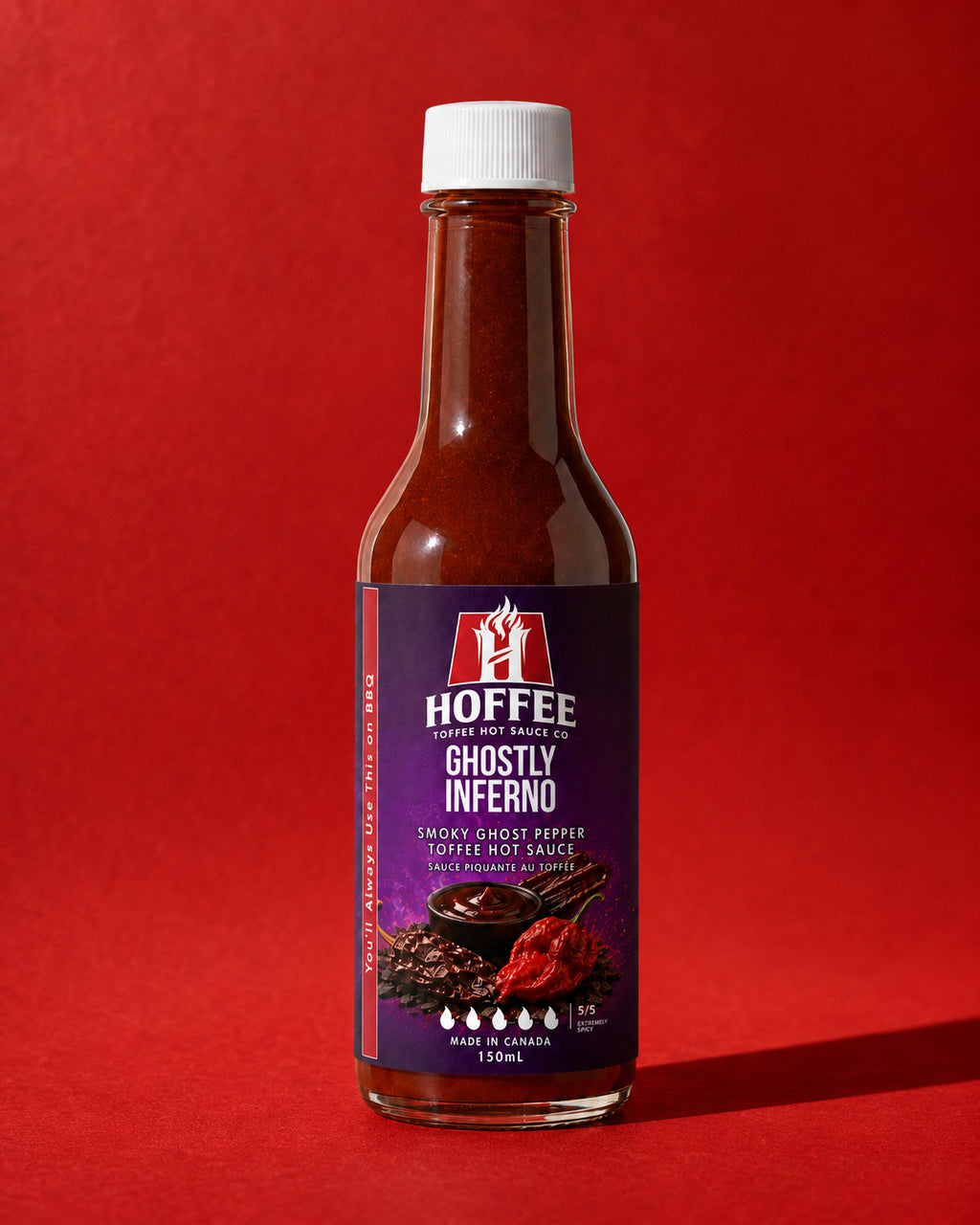 Bottle of Hoffee Ghostly Inferno hot sauce on a red background