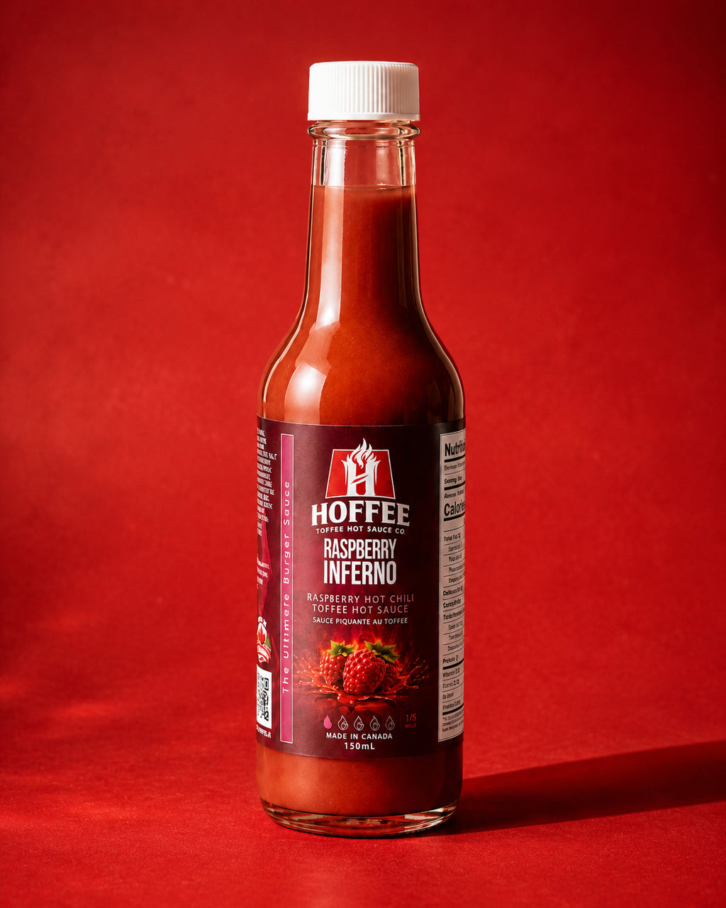 Bottle of Hoffee Raspberry Inferno hot sauce on a red background